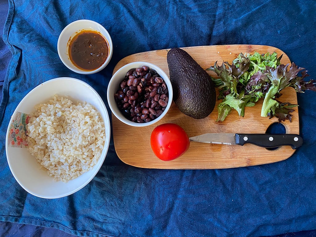 chipotle burrito bowl ingredients - rice, black beans, chipotle sauce, tomato, avocado, lettuce, all you need for this delicious chipotle bowl recipe