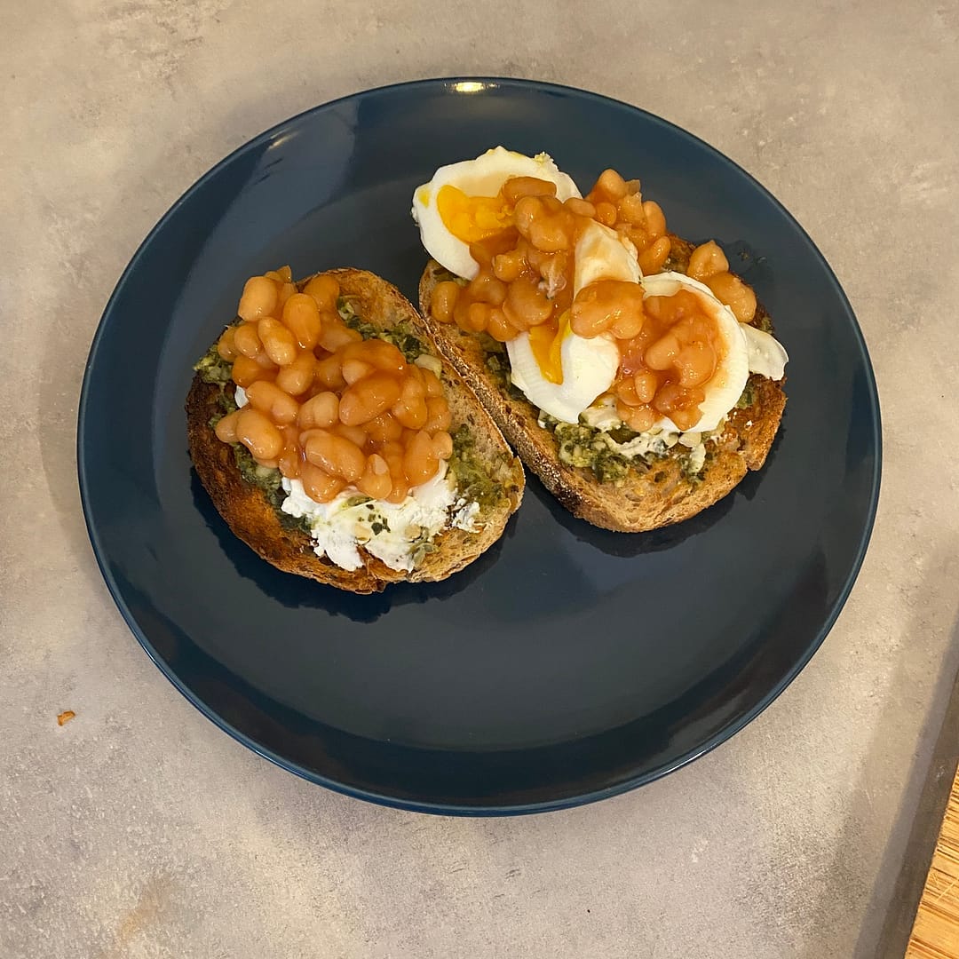 baked beans pesto and goats cheese with eggs on one slice of toast